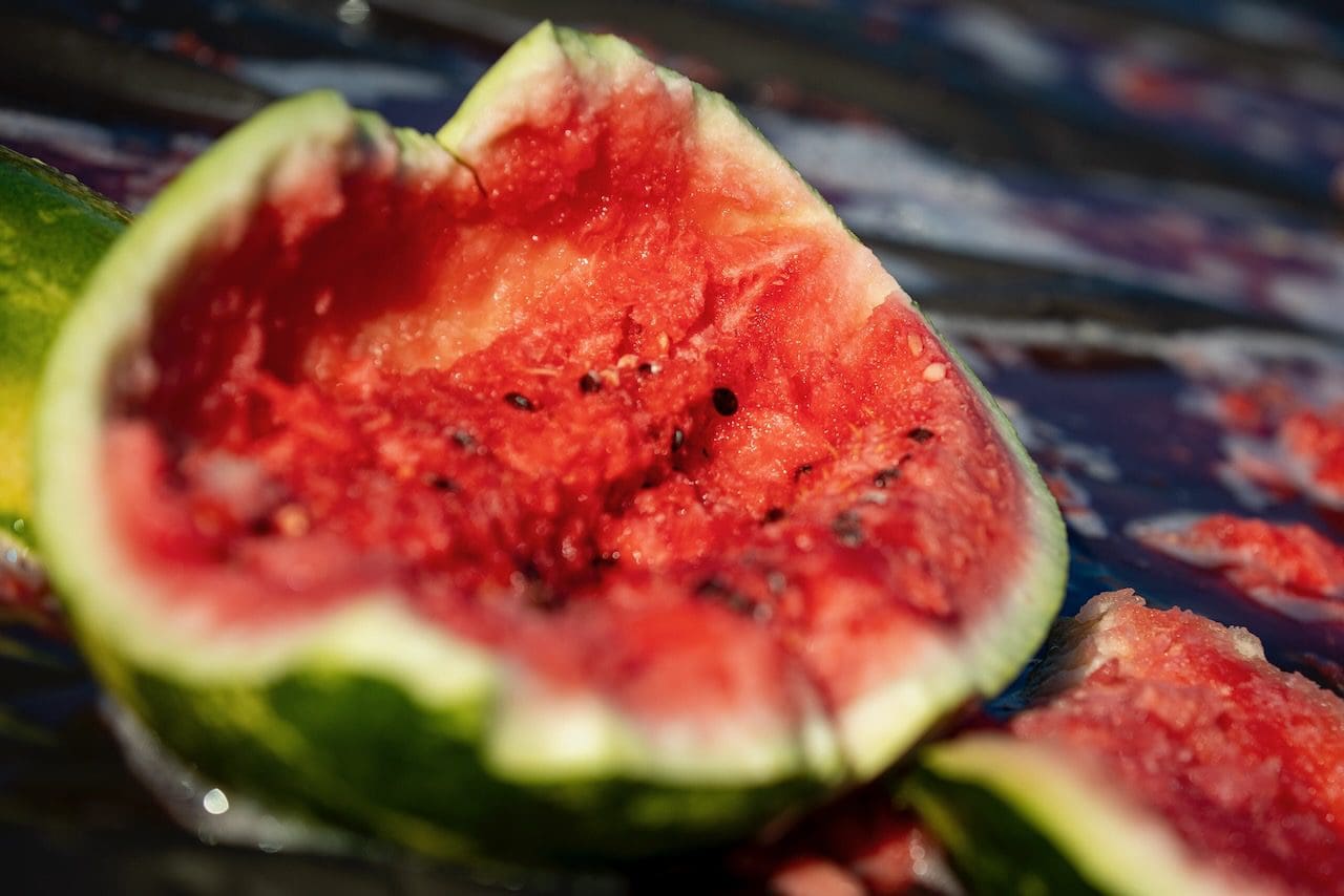 Sliced watermelon with seeds on surface.