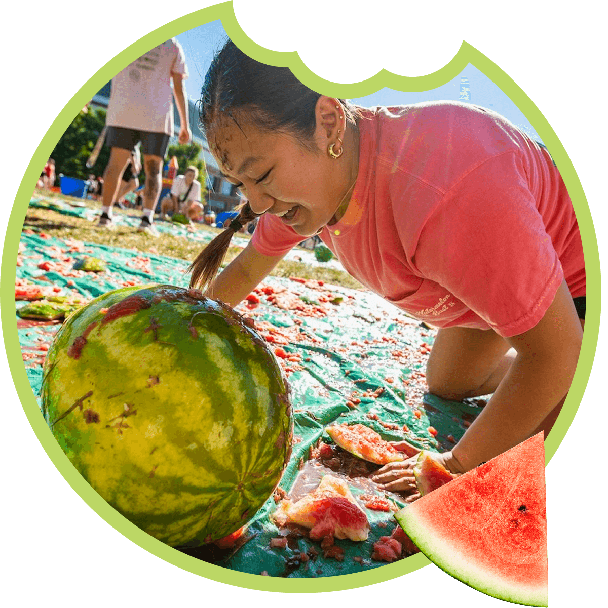 Person enjoying watermelon festival on green tarp.