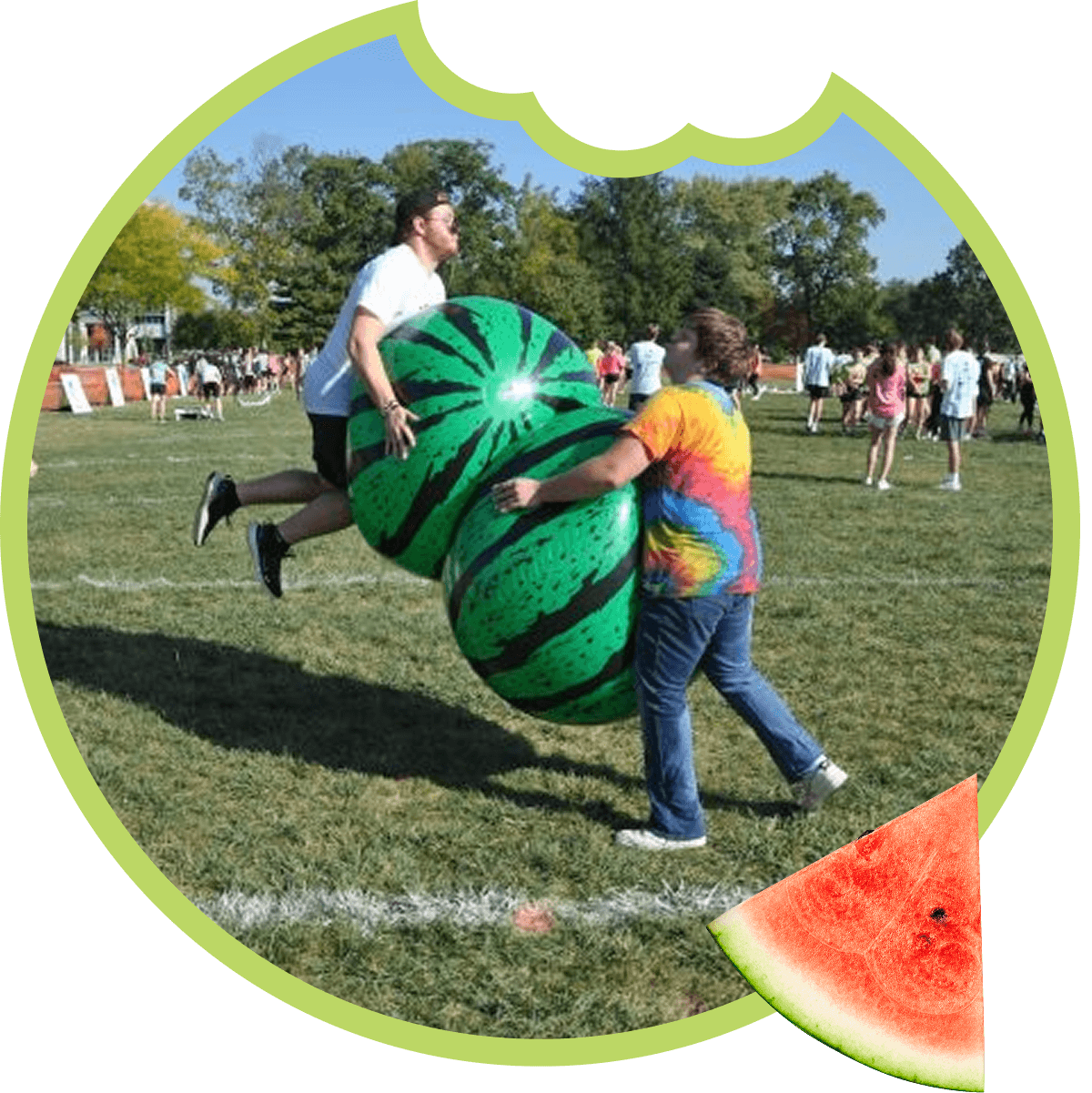 People playing with large watermelon inflatable outdoors.