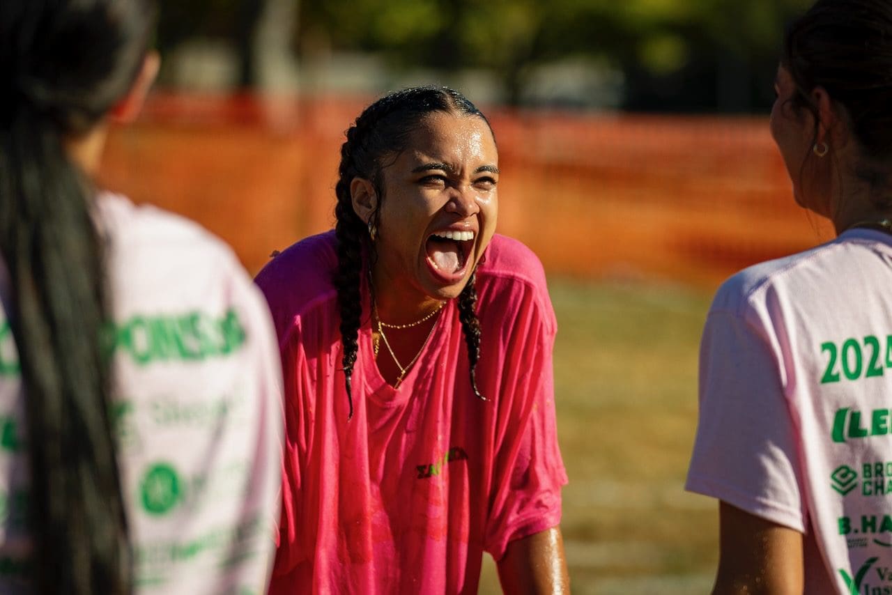 Woman laughing outdoors with friends.