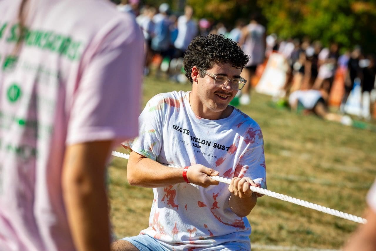 Man participating in outdoor tug-of-war game.