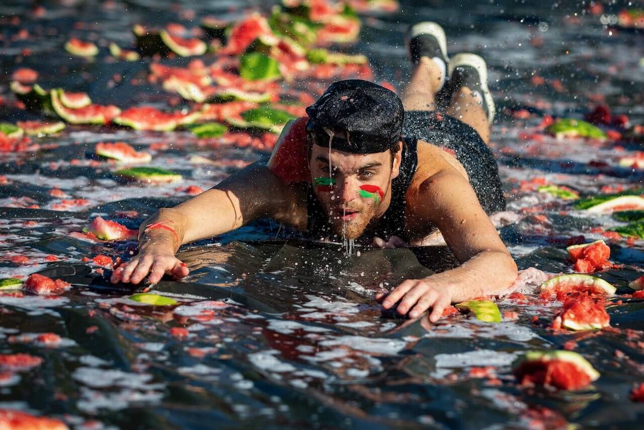 Person sliding on watermelon-covered surface.
