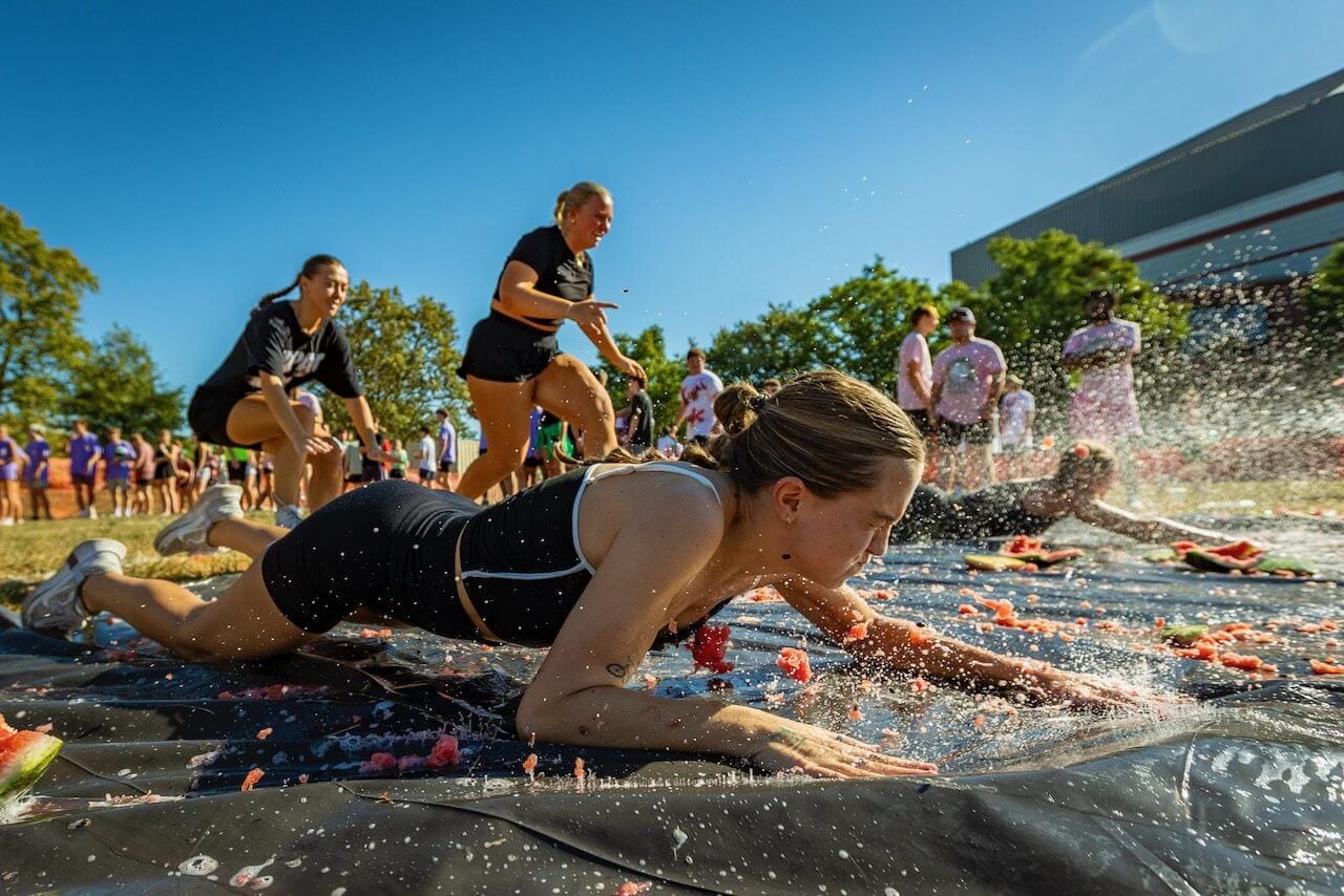 People participating in an outdoor watermelon race.