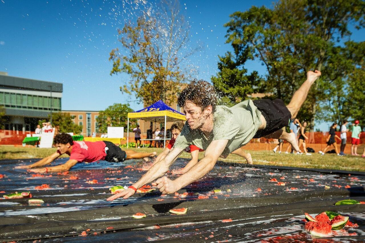 People sliding on watermelons in a race.
