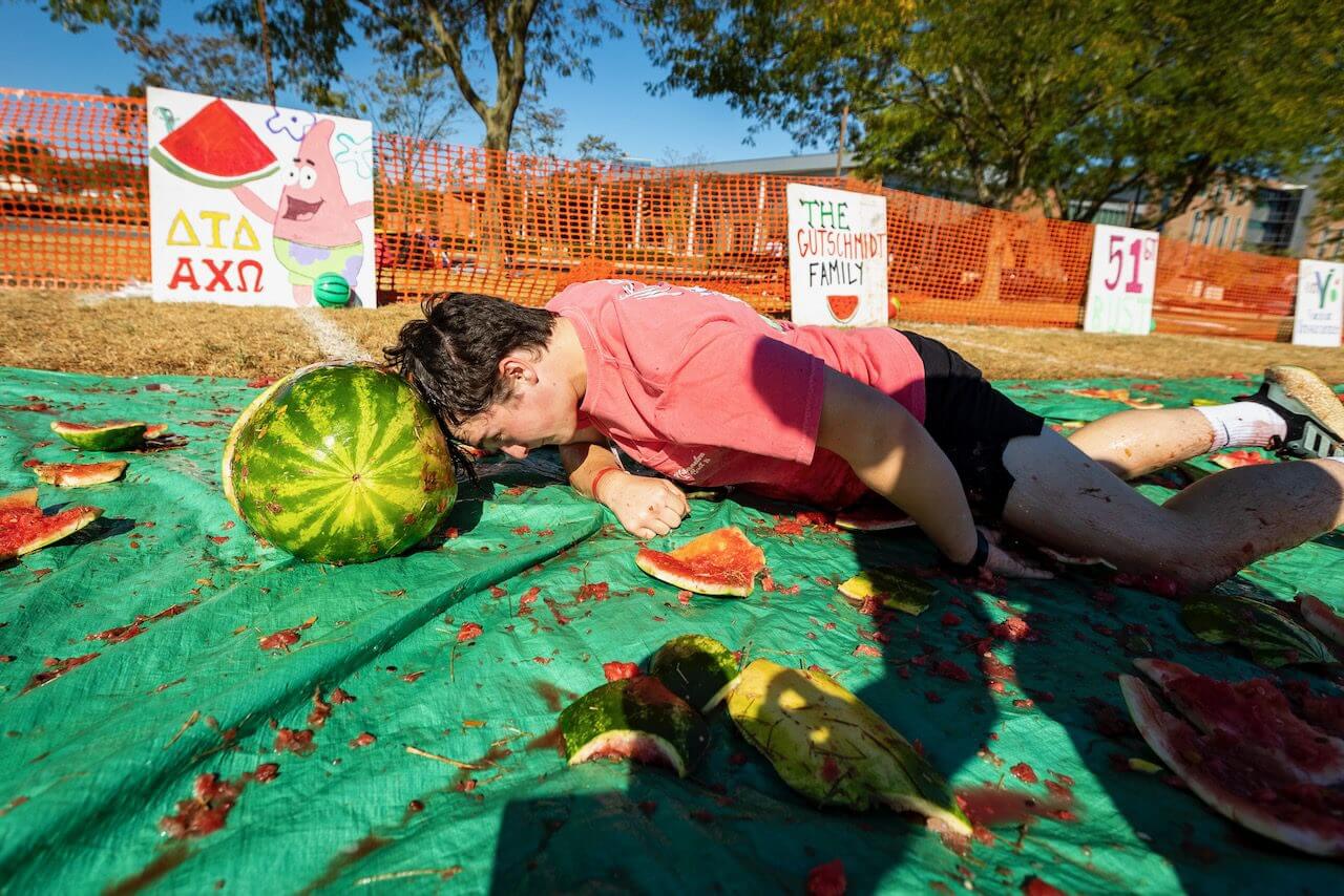 Person face-first in watermelon on ground.