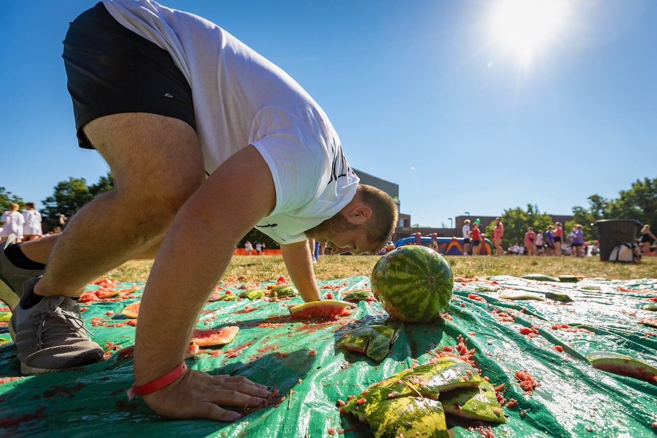Man participates in watermelon festival contest.