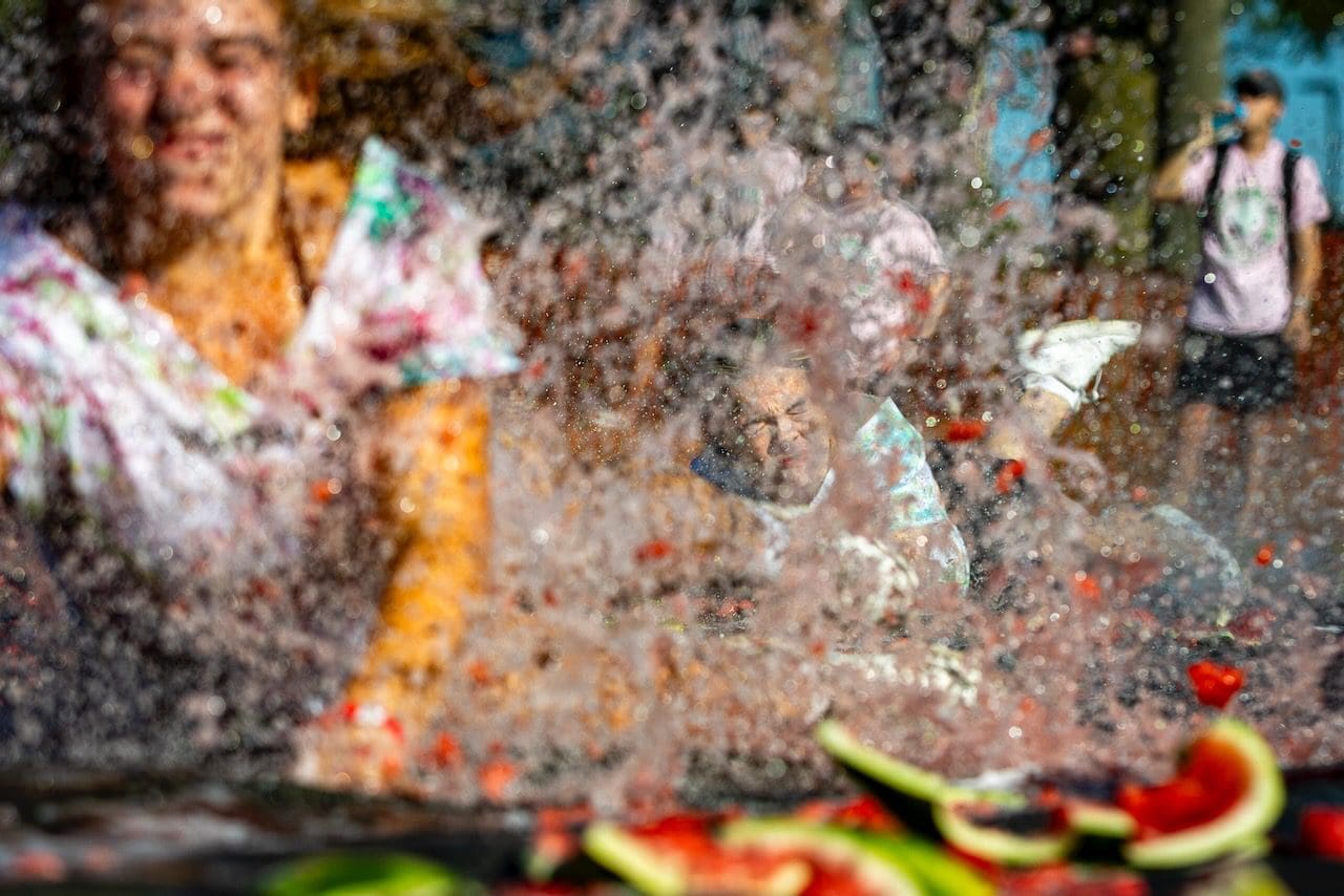 People enjoying a vibrant watermelon festival splash.