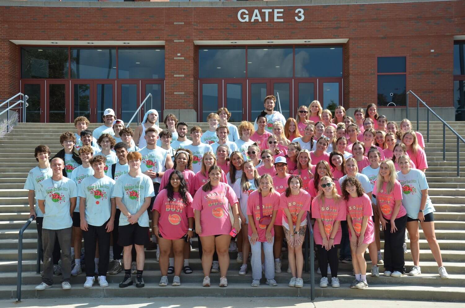 Group of people standing on steps outside.